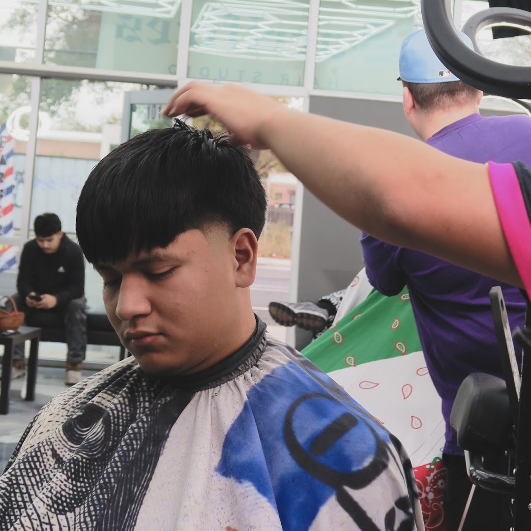 The Sacrifices storefront — barber pole on the window, shop life inside.